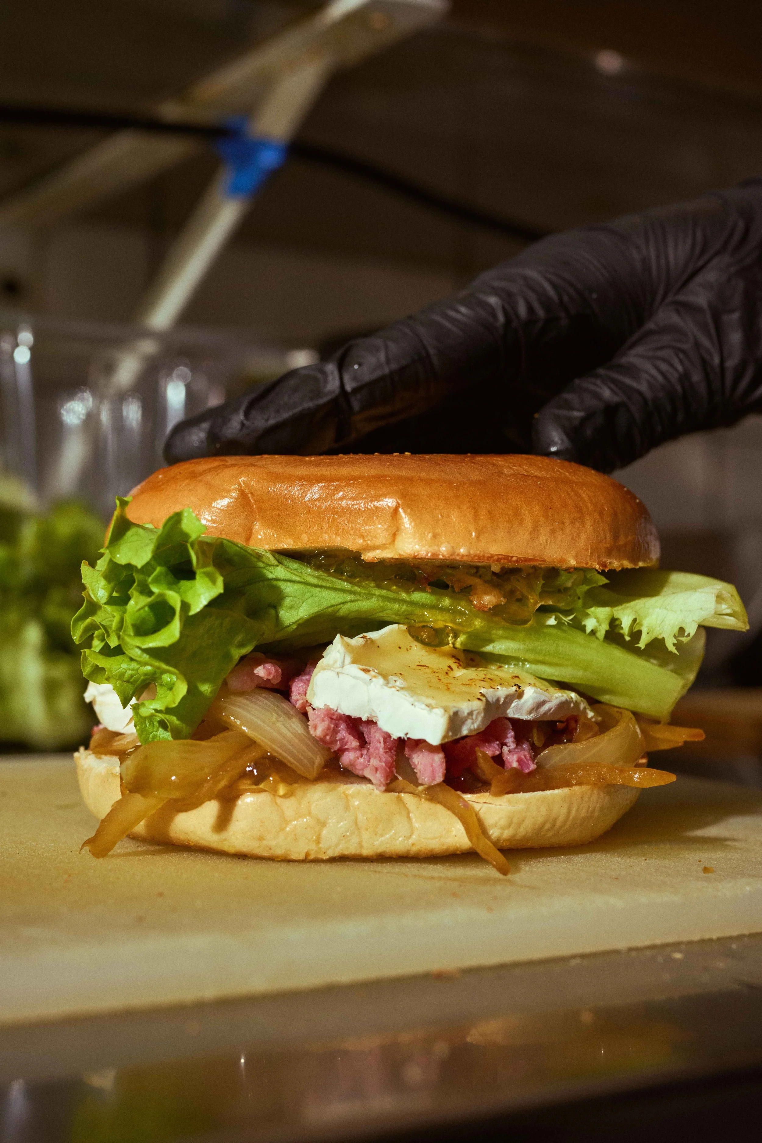 Bagel généreux au camembert, oignons confits, lardons et salade