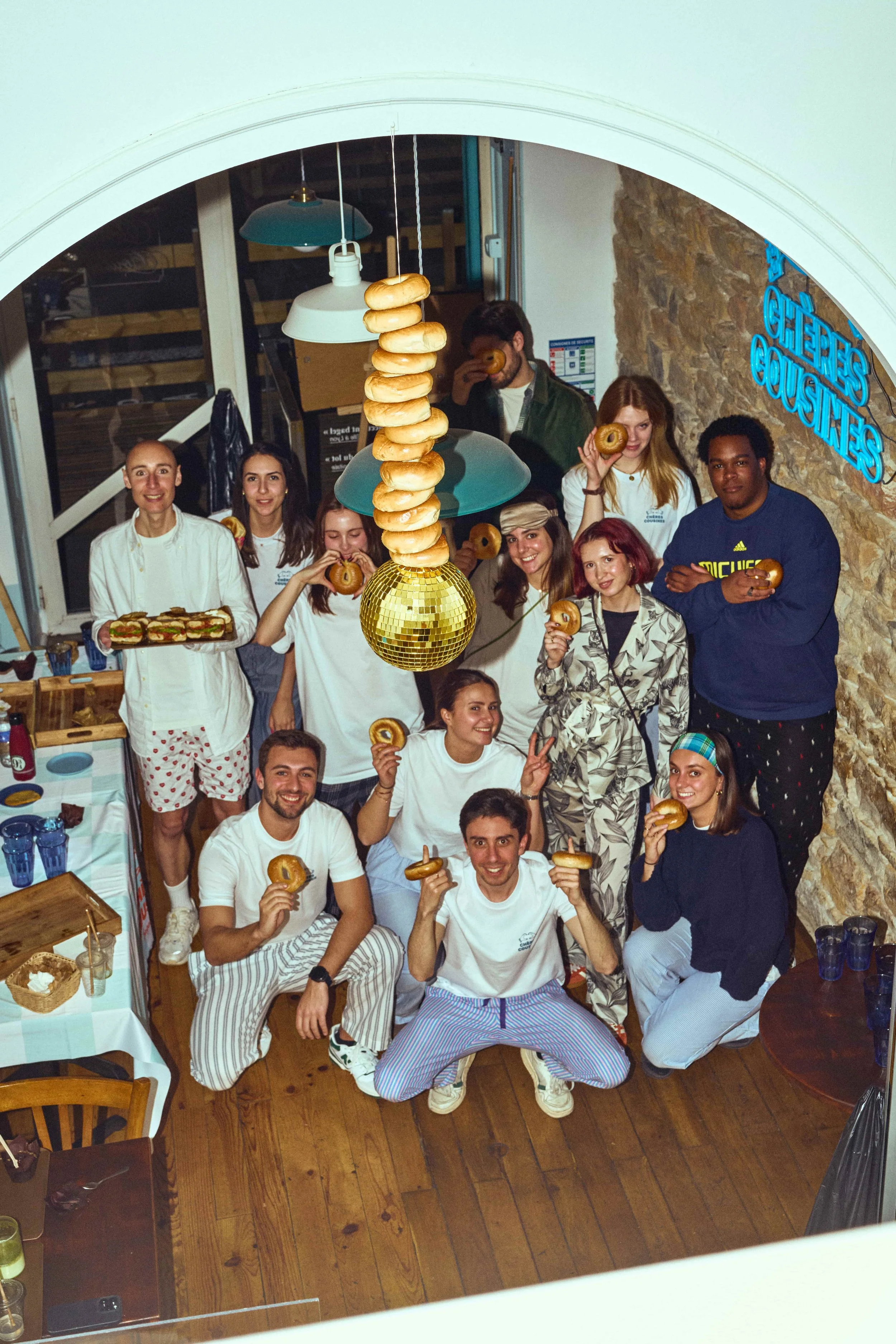 L'équipe Chères Cousines et ses clients avec des bagels dans le restaurant à Lyon lors d'une cousinade