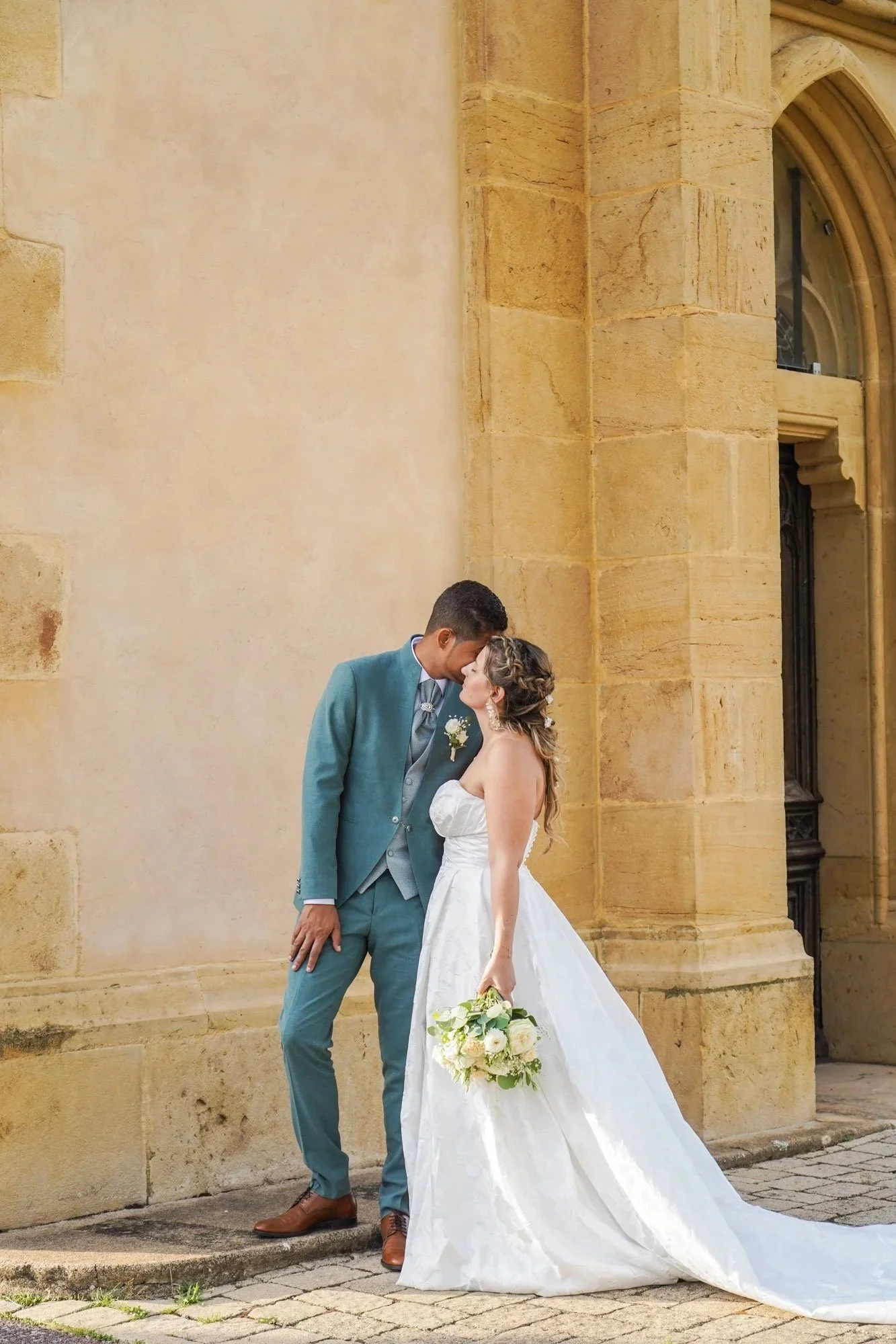 Photo mariage couple tête contre tête, bâtiment en pierre.