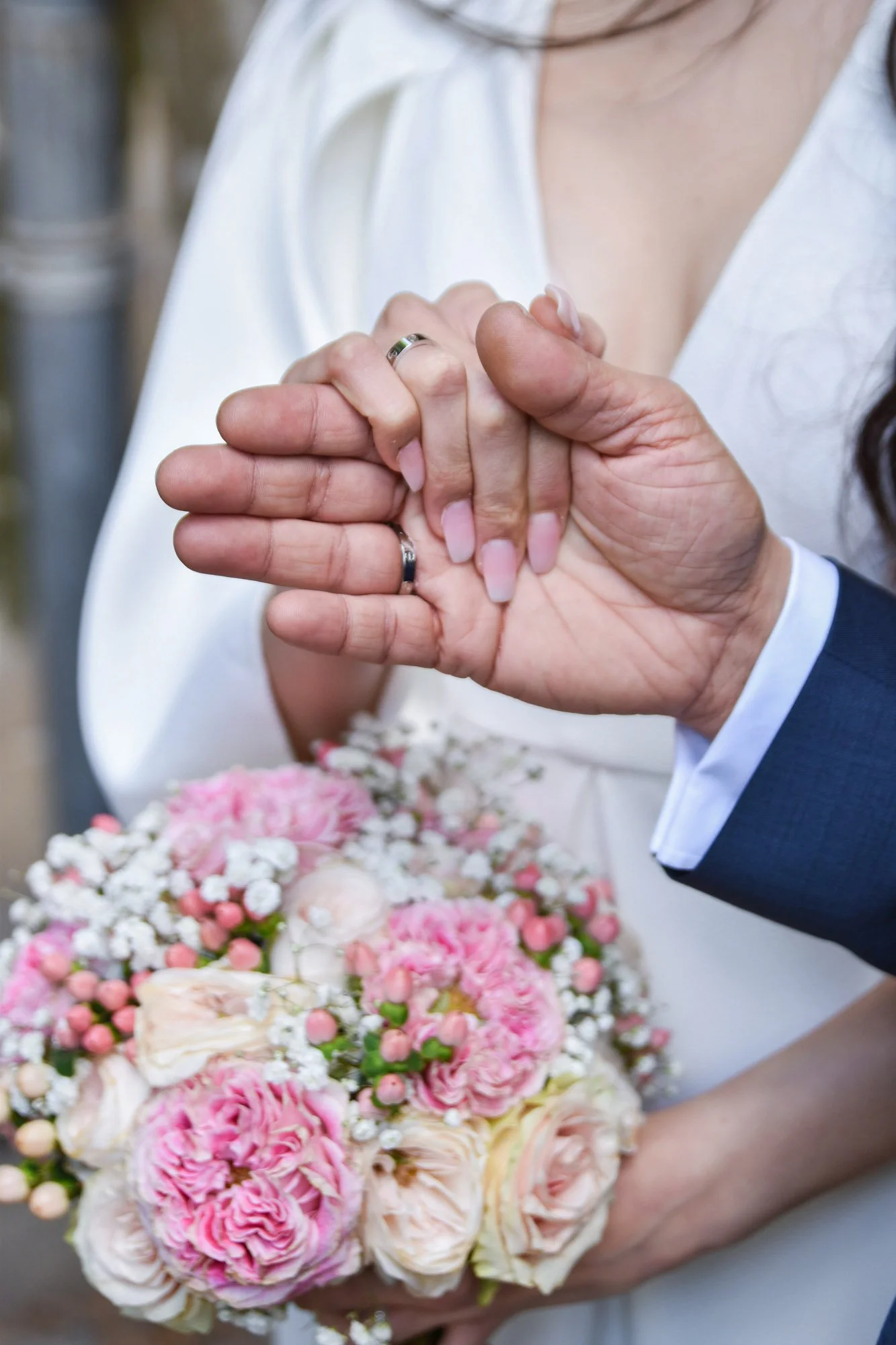 Mariés avec alliances et bouquet de fleurs.