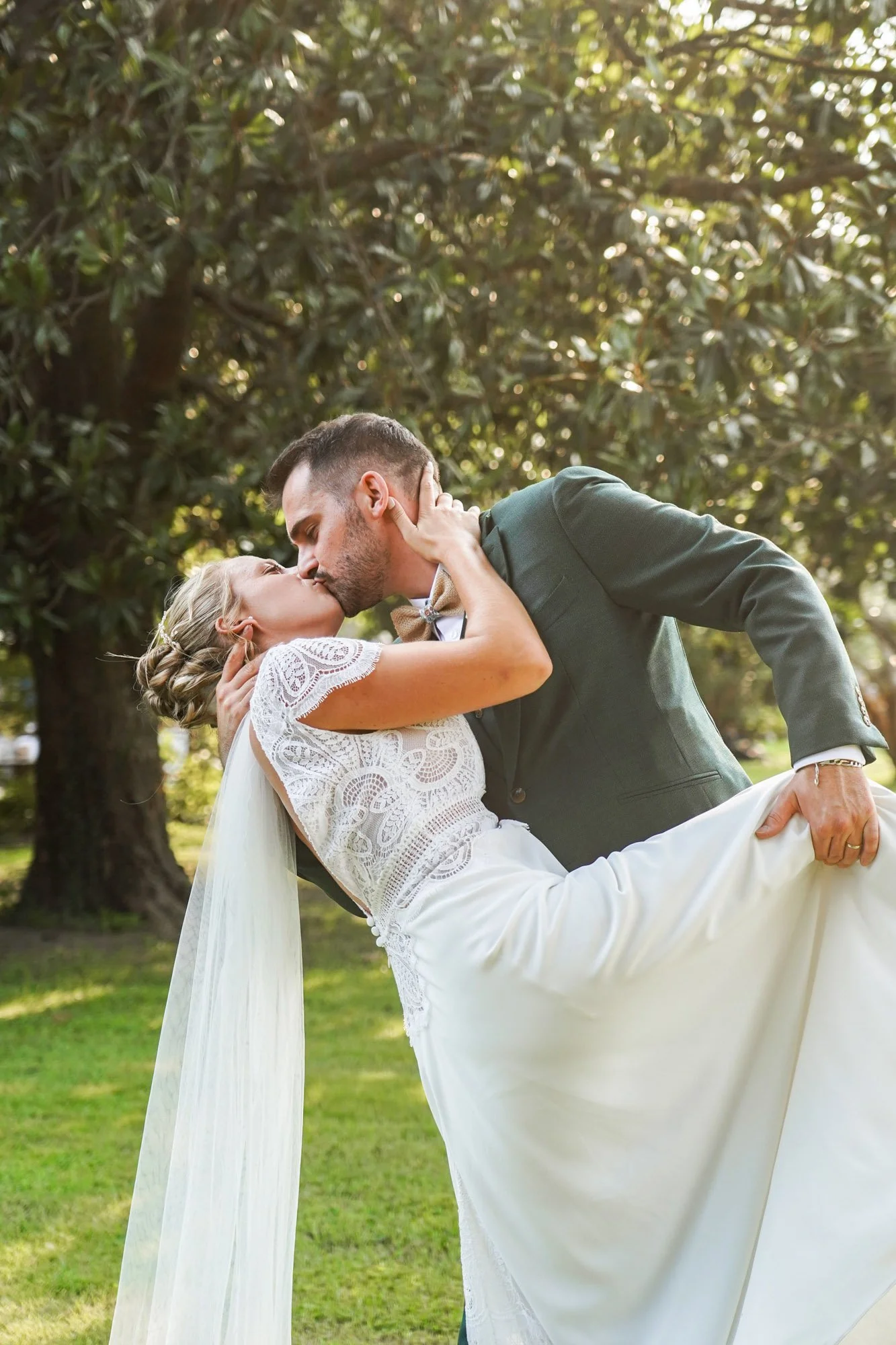 Couple marié baiser coucher du soleil dans parc verdoyant.
