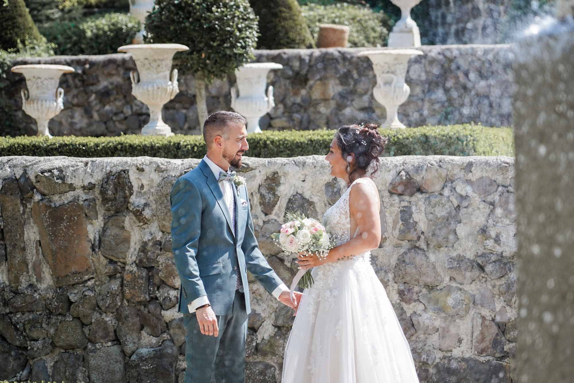 Portrait couplé mariés naturel devant mur en pierre.