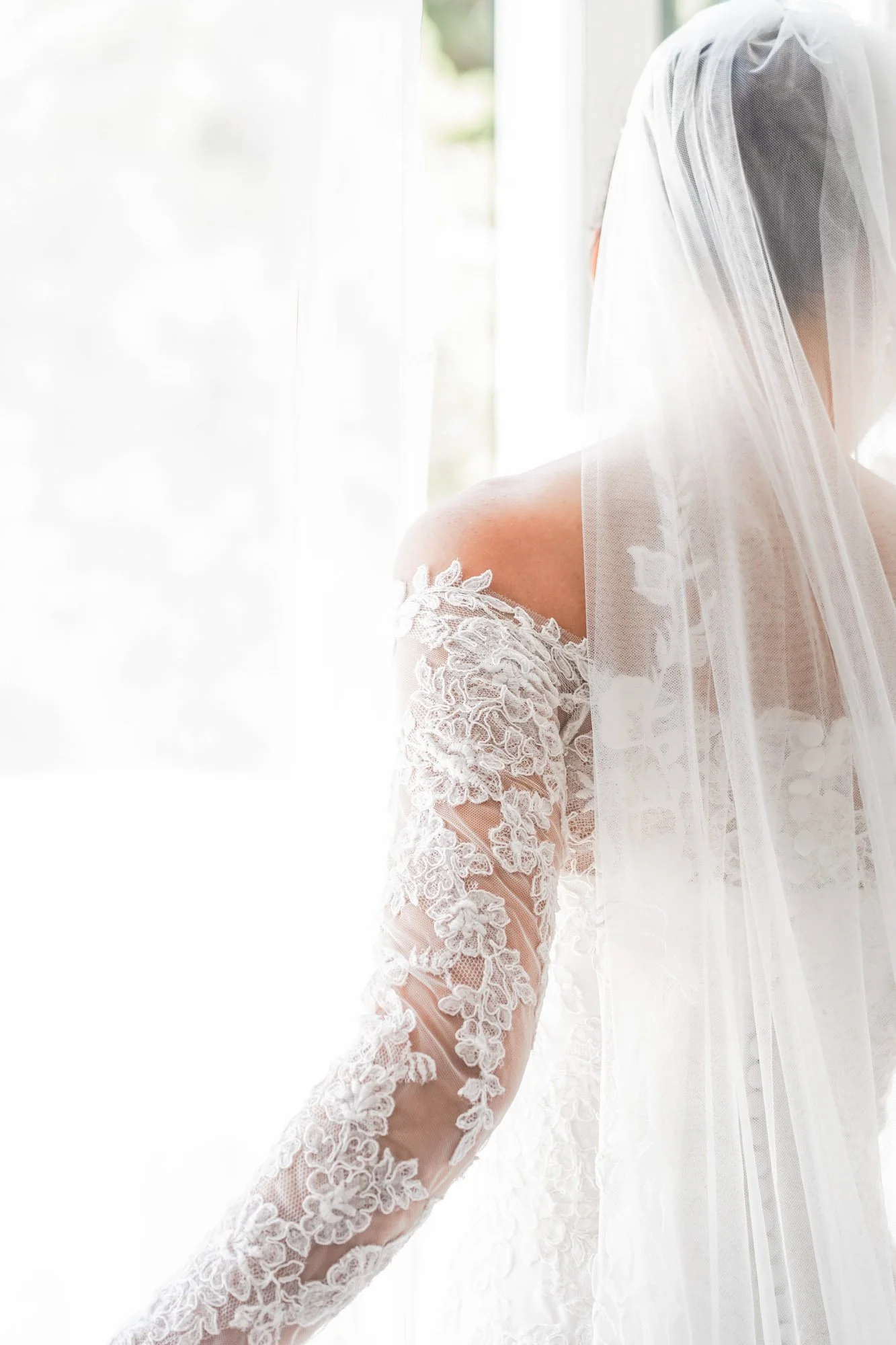 Détail d'une robe de mariage en dentelle blanche avec voile.