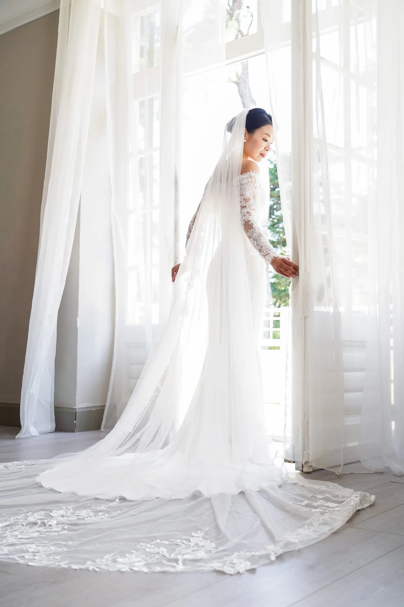 Robe de mariée blanche longue traine. Portait mariée lumière naturelle.