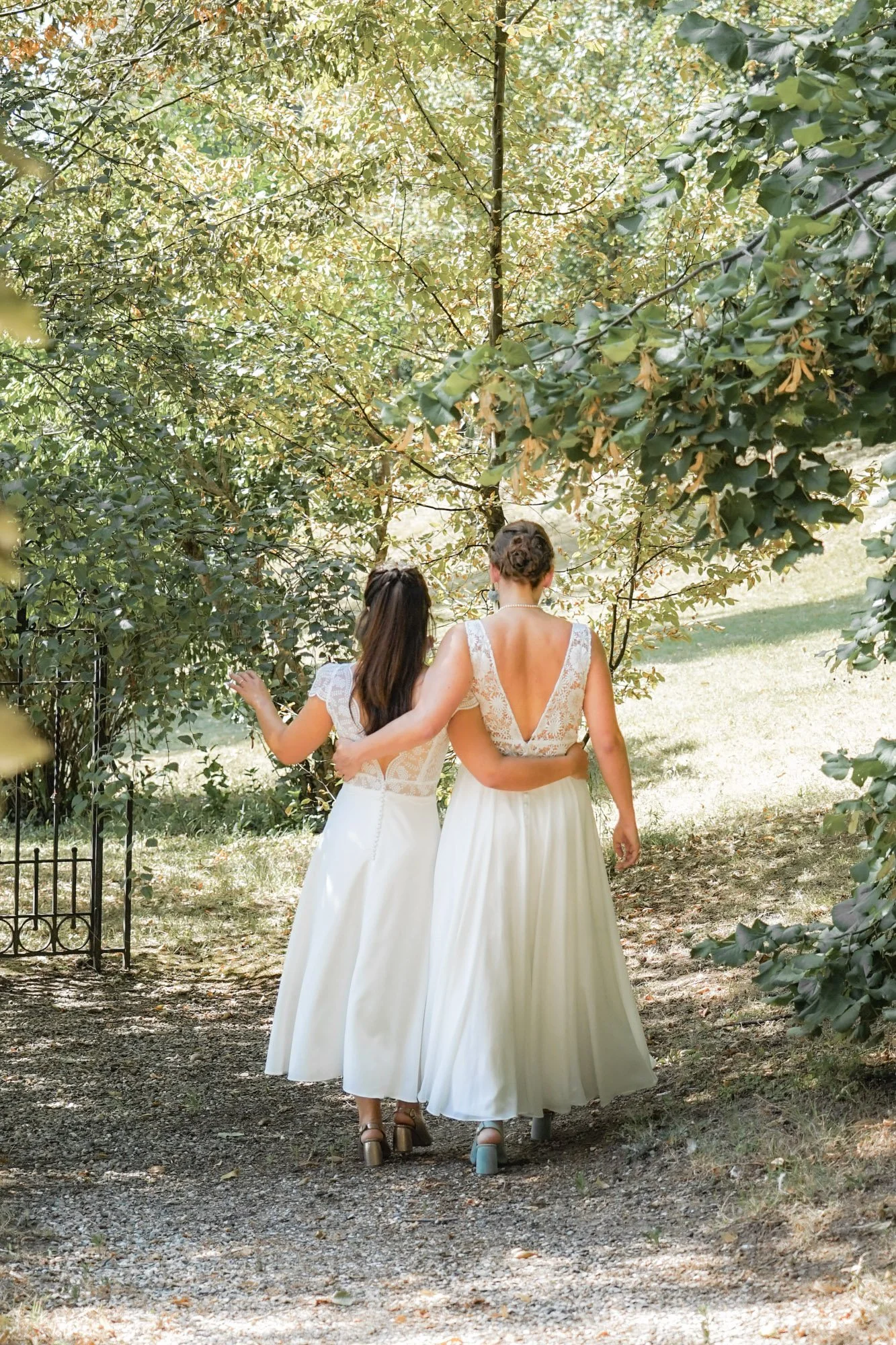 Mariage lgbt femmes, robes de mariée blanches, vues de dos.