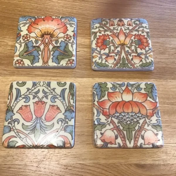 Square blue, red & white coasters with pictures of flowers on them