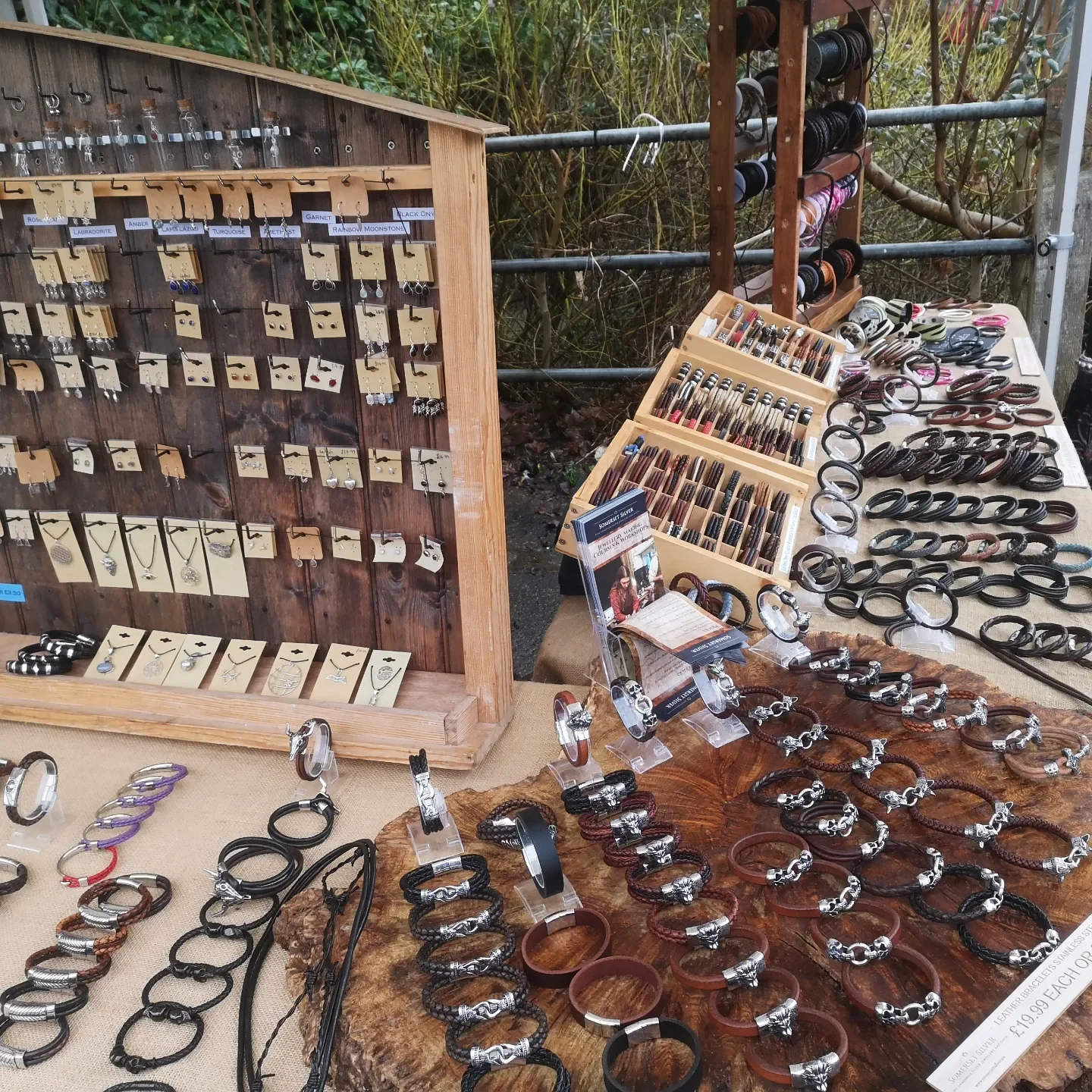 Various silver clasped bands and silver jewelry laid out on a stall
