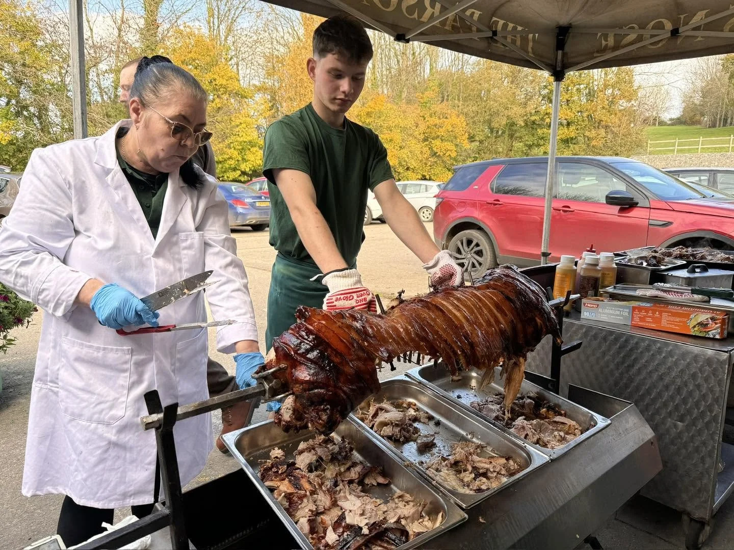 people carving crackling on a spit