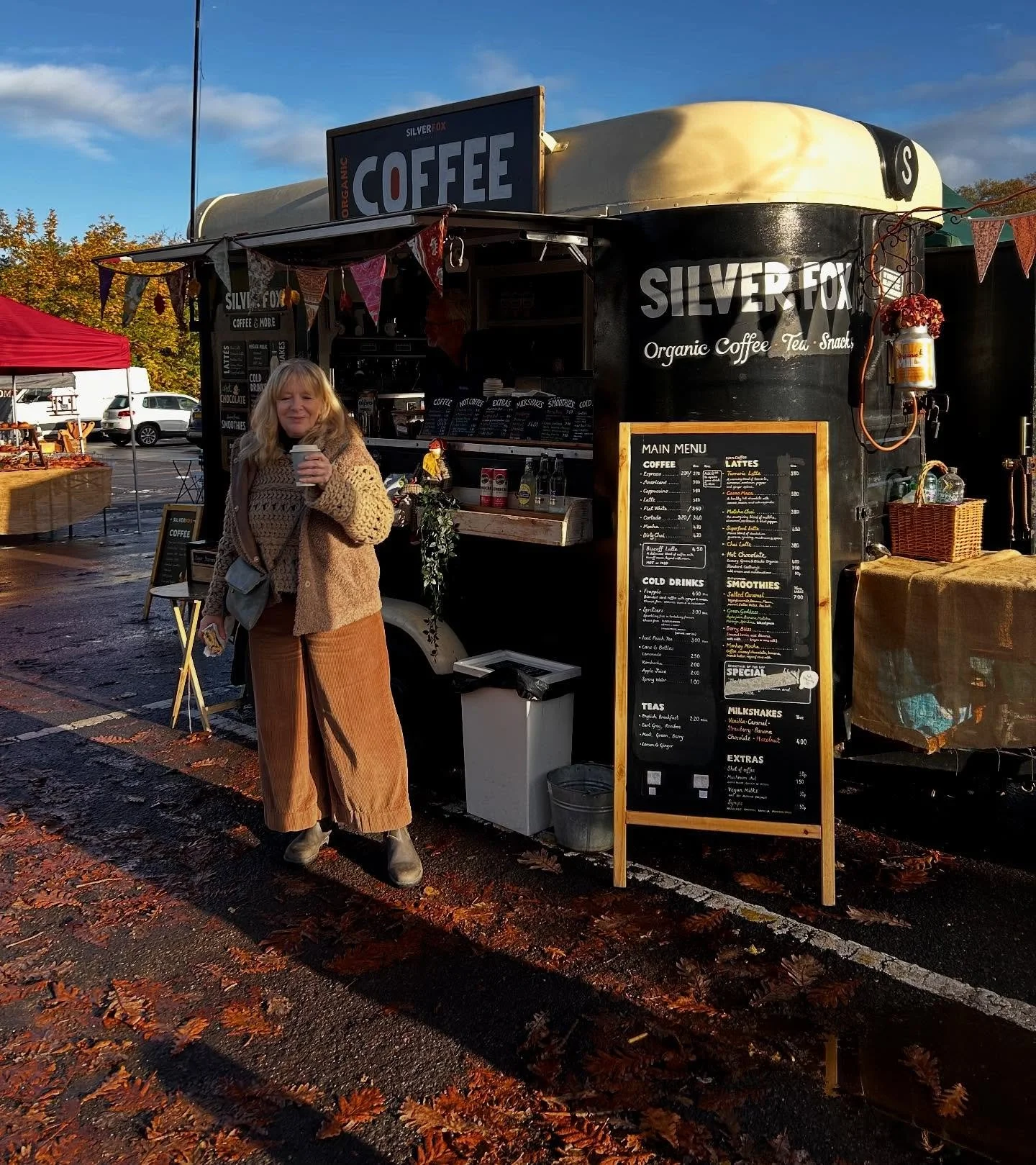 one person holding a mug in front of the cafe