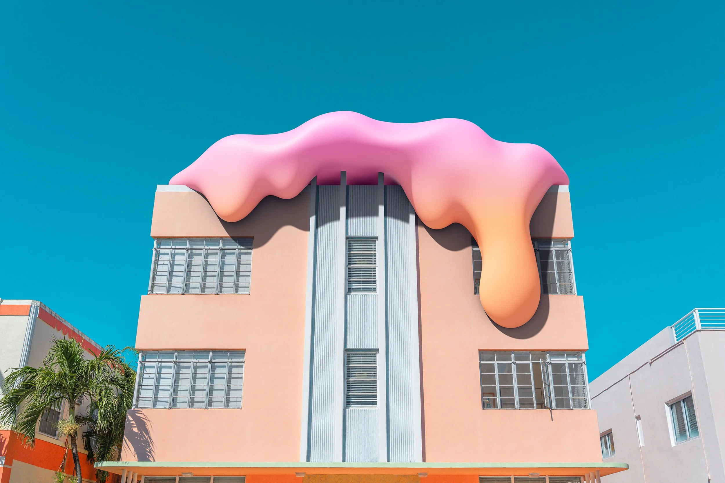 Artistic building with peach-colored facade, featuring a pink and orange dripping roof that resembles melting ice cream, against a clear blue sky.