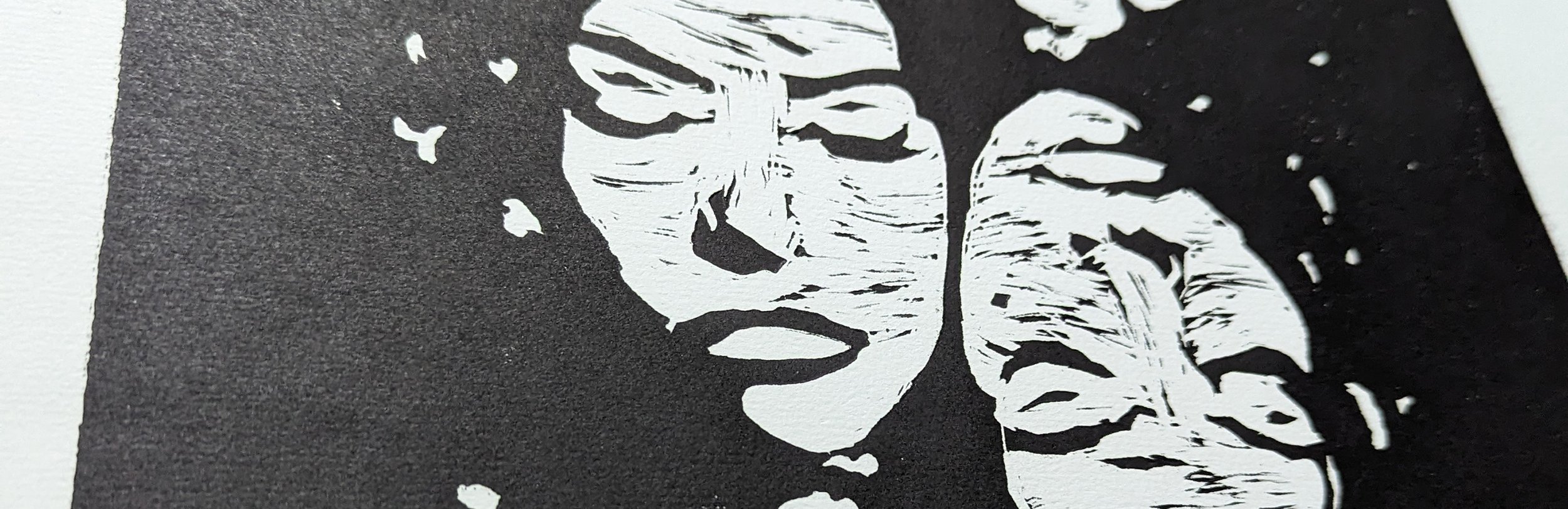 Close-up of a black-and-white stencil art featuring a person's face, with glasses and a bald head, on black textured background.