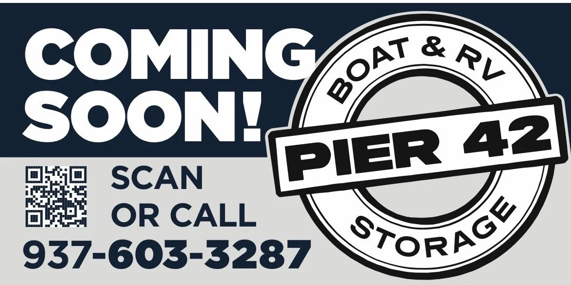 Sign advertising upcoming boat and RV storage at Pier 42, featuring a QR code, contact phone number 937-603-3287, and text indicating options to scan or call.