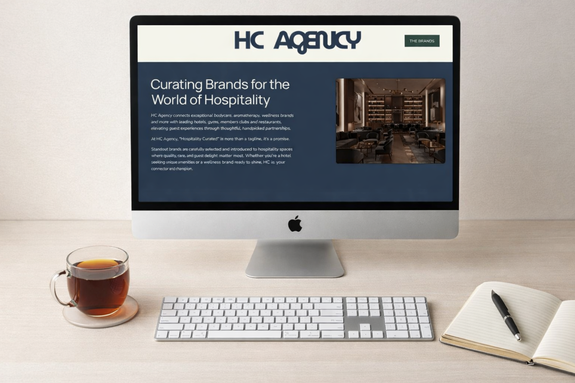 image of a desk with a cup of tea and a desktop and keyboard