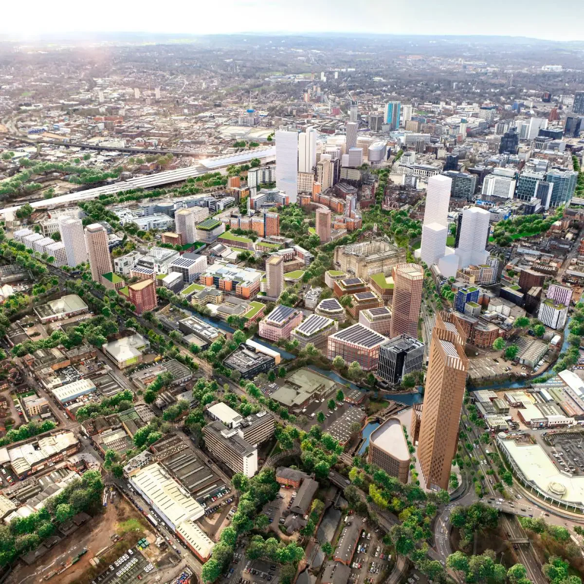 Aerial view of a cityscape with tall buildings, green spaces, and roads.