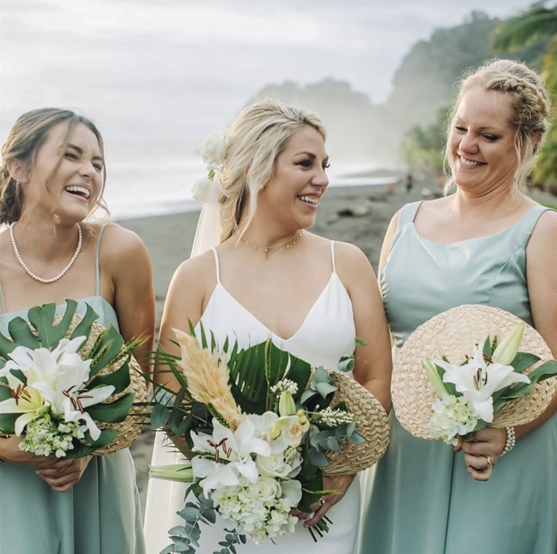 A joyful, candid beach wedding moment with a bride and her bridesmaids, featuring natural and long-lasting styling by Cecilia Acquaroli for a coastal celebration.