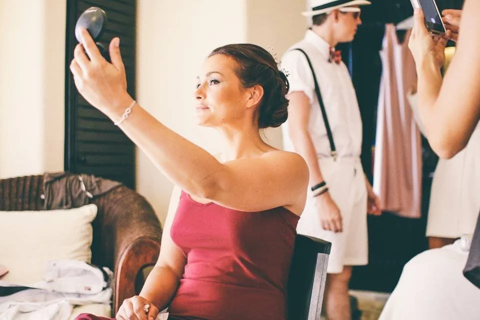 A bride looking in the mirror after the Makeup and hair styling application. she smiles