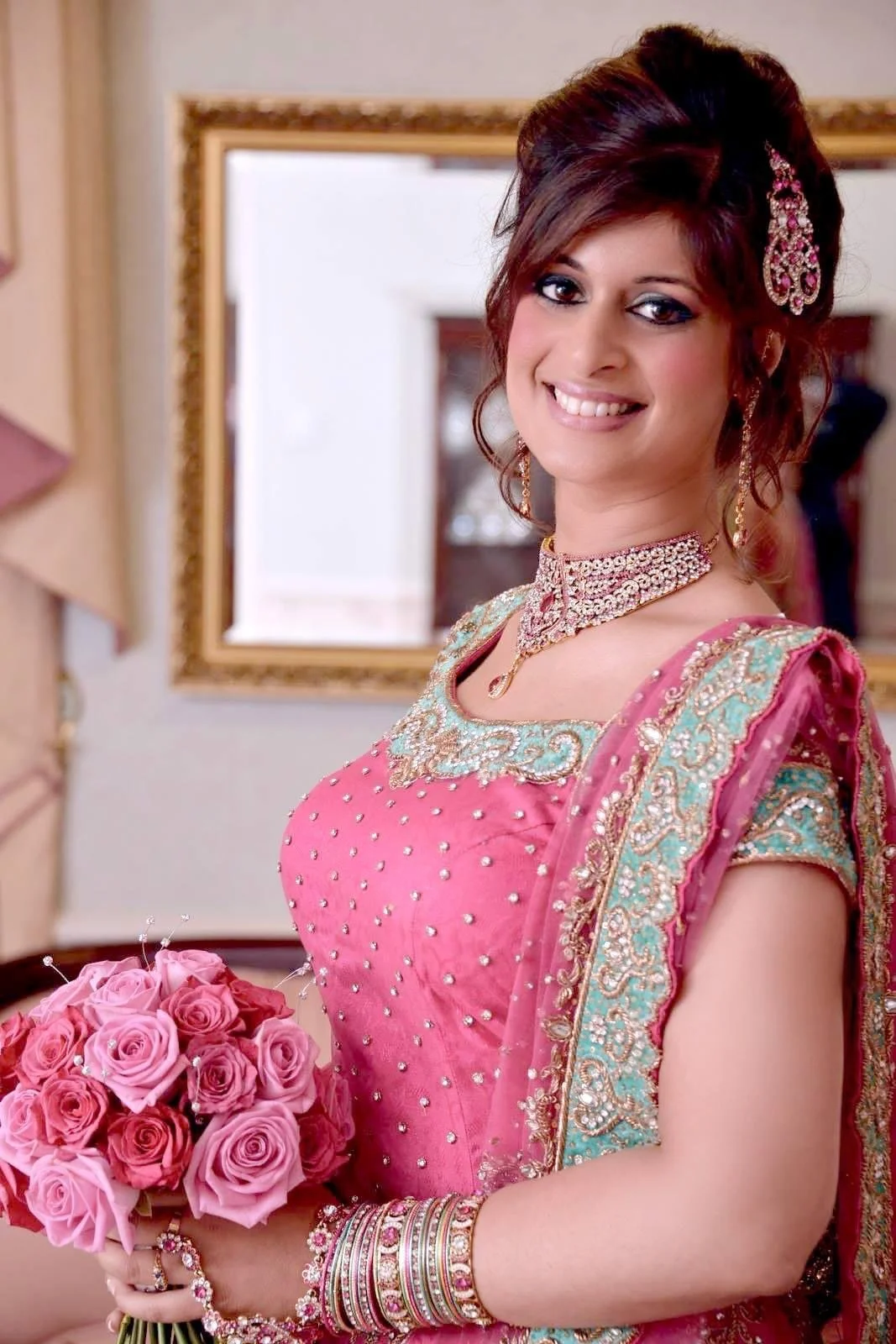 Radiant traditional bridal beauty featuring vibrant pink attire and intricate jewelry, with expert hair and makeup styling by Cecilia Acquaroli in Rome.