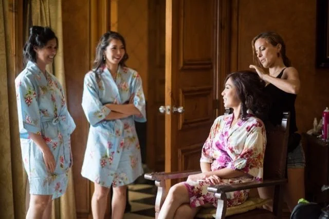the preparation time in. a bridal suite in a. villa in Rome, featuring the bridesmaids chatting as the bridal stylist Cecilia prepares the bride 