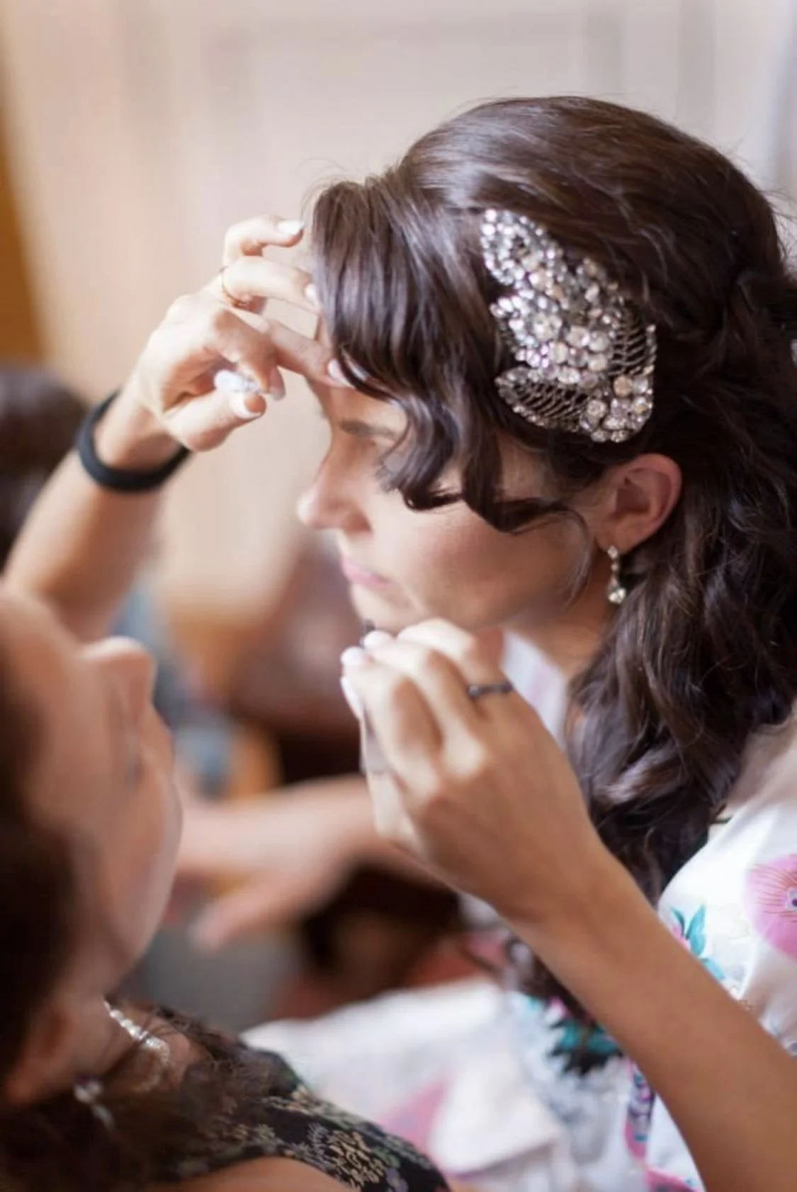 Professional bridal stylist Cecilia Acquaroli applying a refined, soft-glam makeup look for a destination wedding in Italy, featuring elegant hair styling and a decorative accessory.