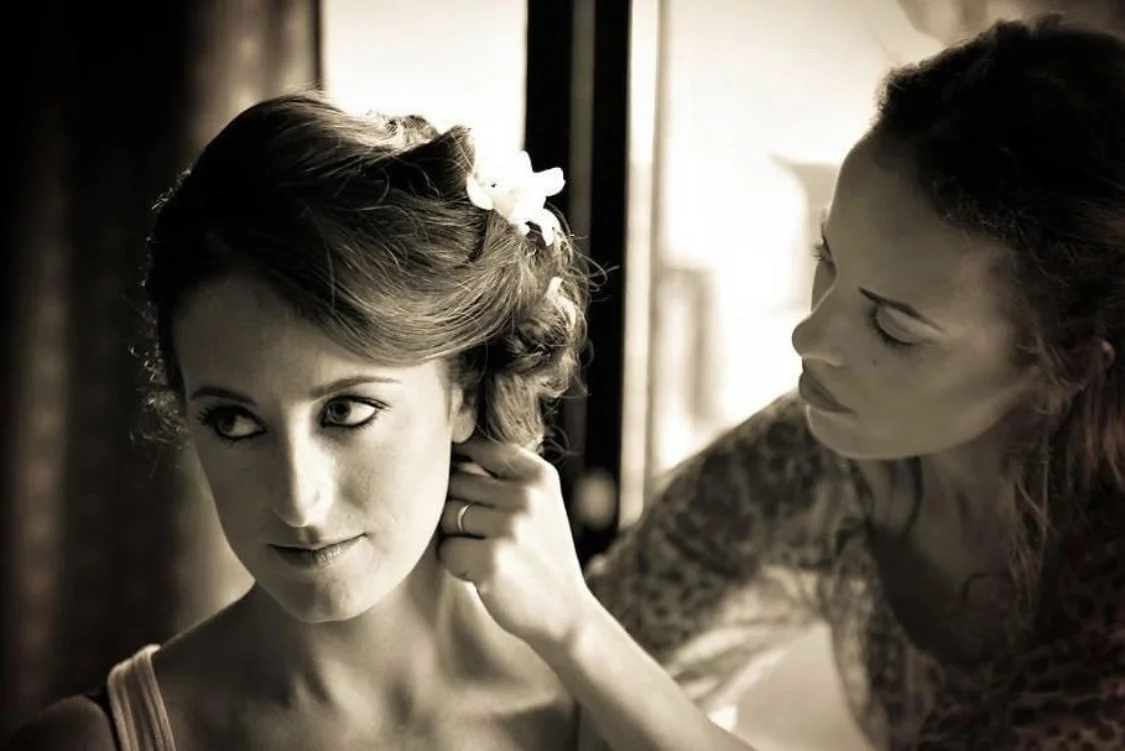 Bridal stylist doing the final adjustments to the bride's look