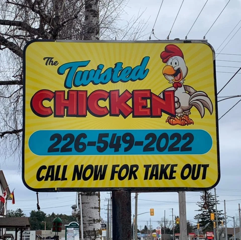 Sign for The Twisted Chicken restaurant with a phone number and call for take out message, featuring a cartoon chicken character.