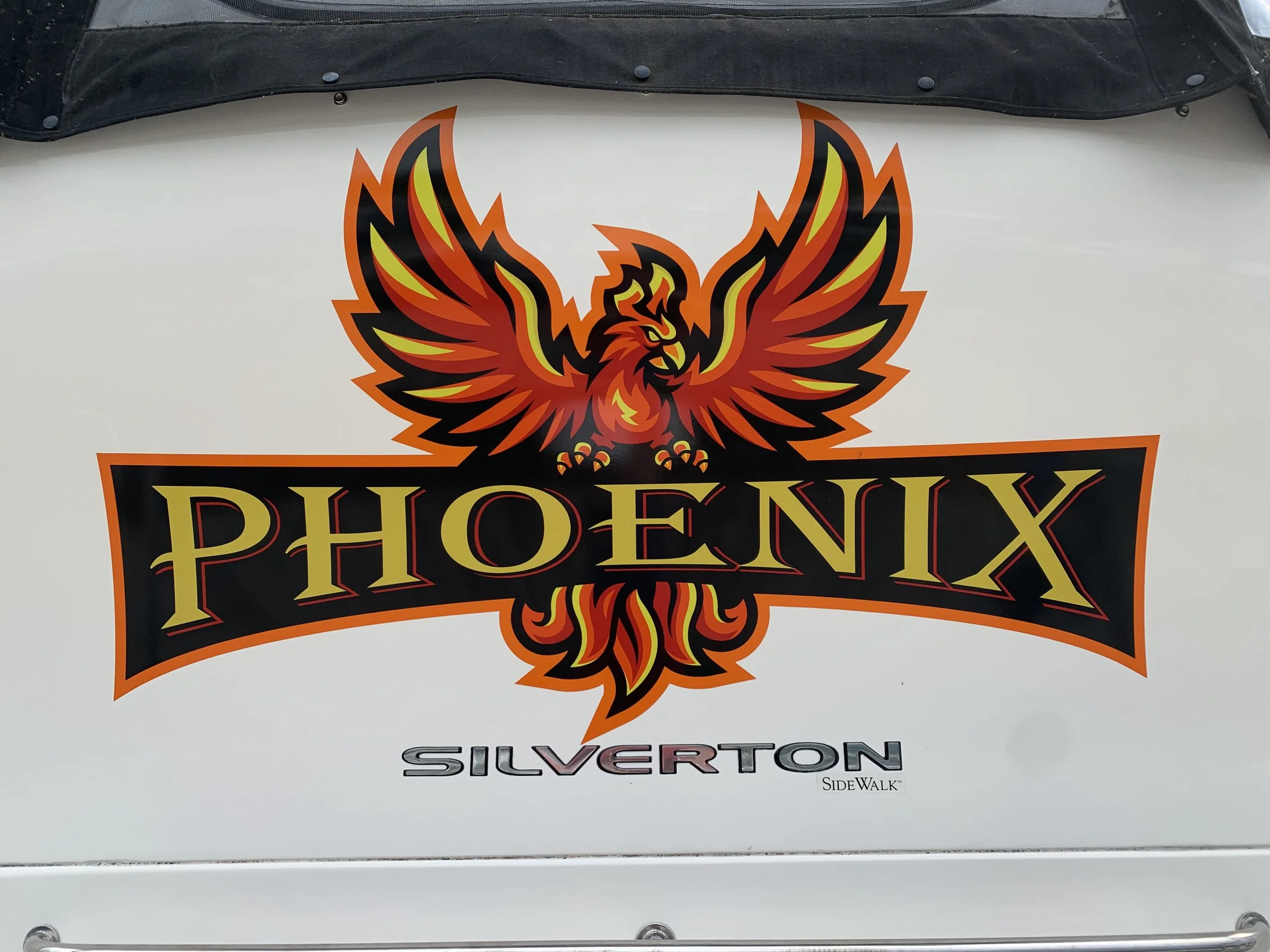 A logo featuring a stylized red and yellow phoenix with black accents, with the text 'PHOENIX' below it in gold and black, and the word 'SILVERTON' underneath in silver, on a white surface.