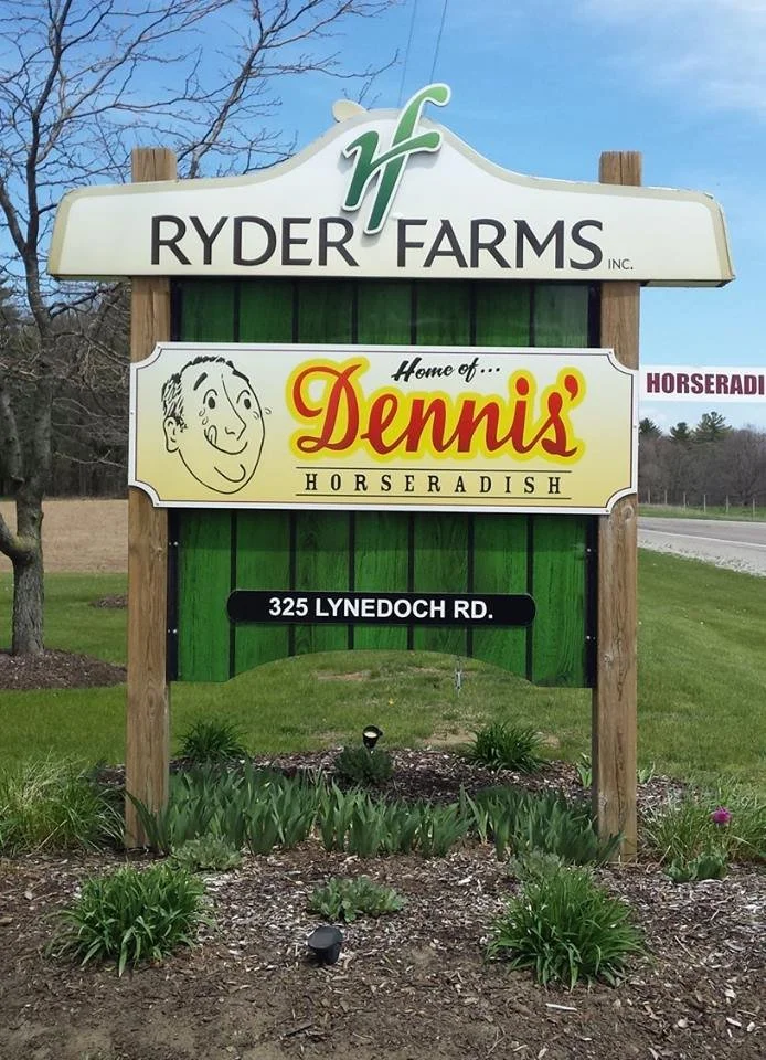 Sign for Ryder Farms and Dennis' Horseradish at 325 Lynedoach Road with a garden and landscaping in front.