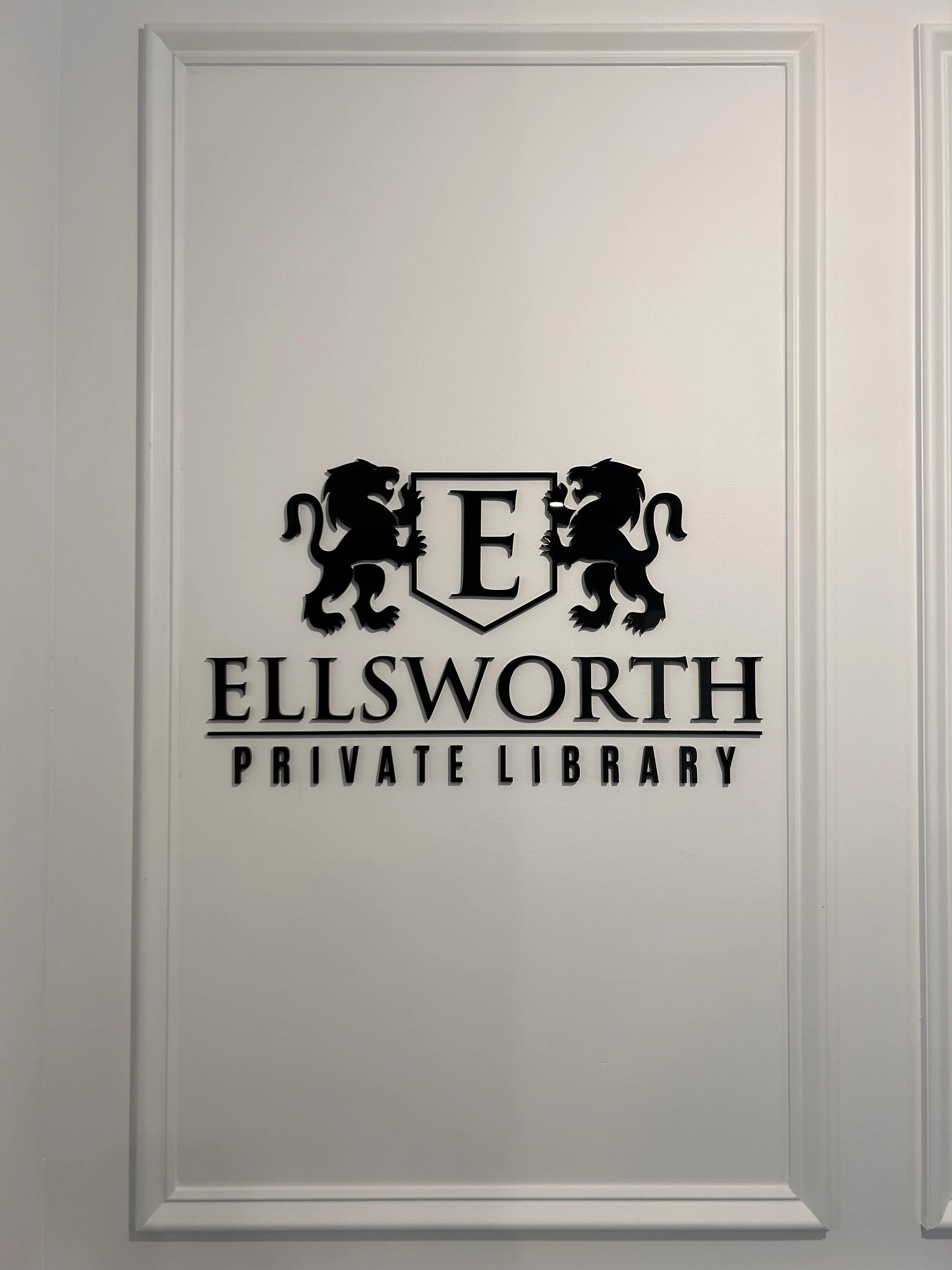 Sign for Ellsworth Private Library featuring two black lions and a shield with the letter E.
