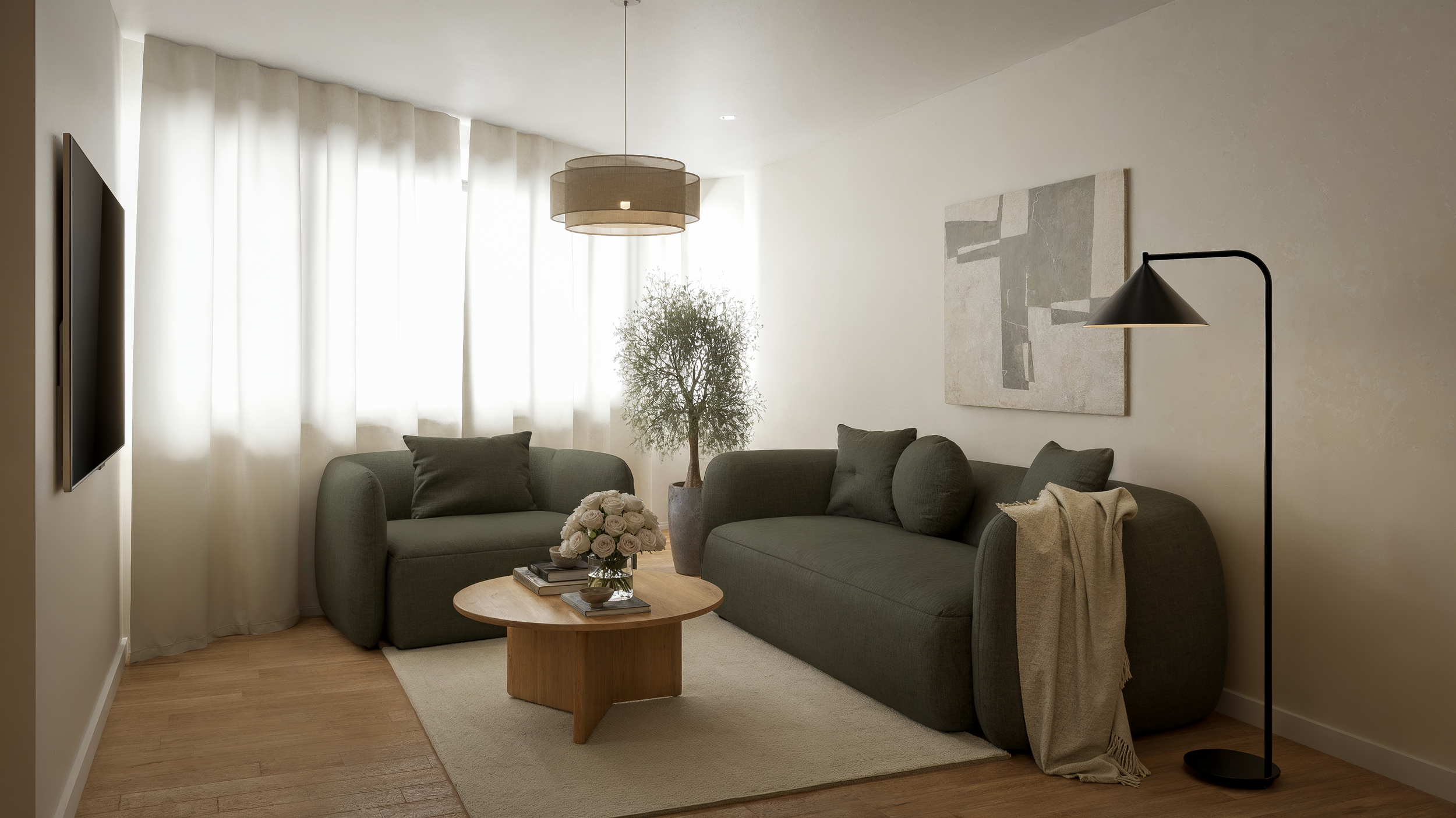 Living room with two green sofas, a wooden coffee table with a flower arrangement, potted tree, wall art, floor lamp, and cream curtains letting in natural light.