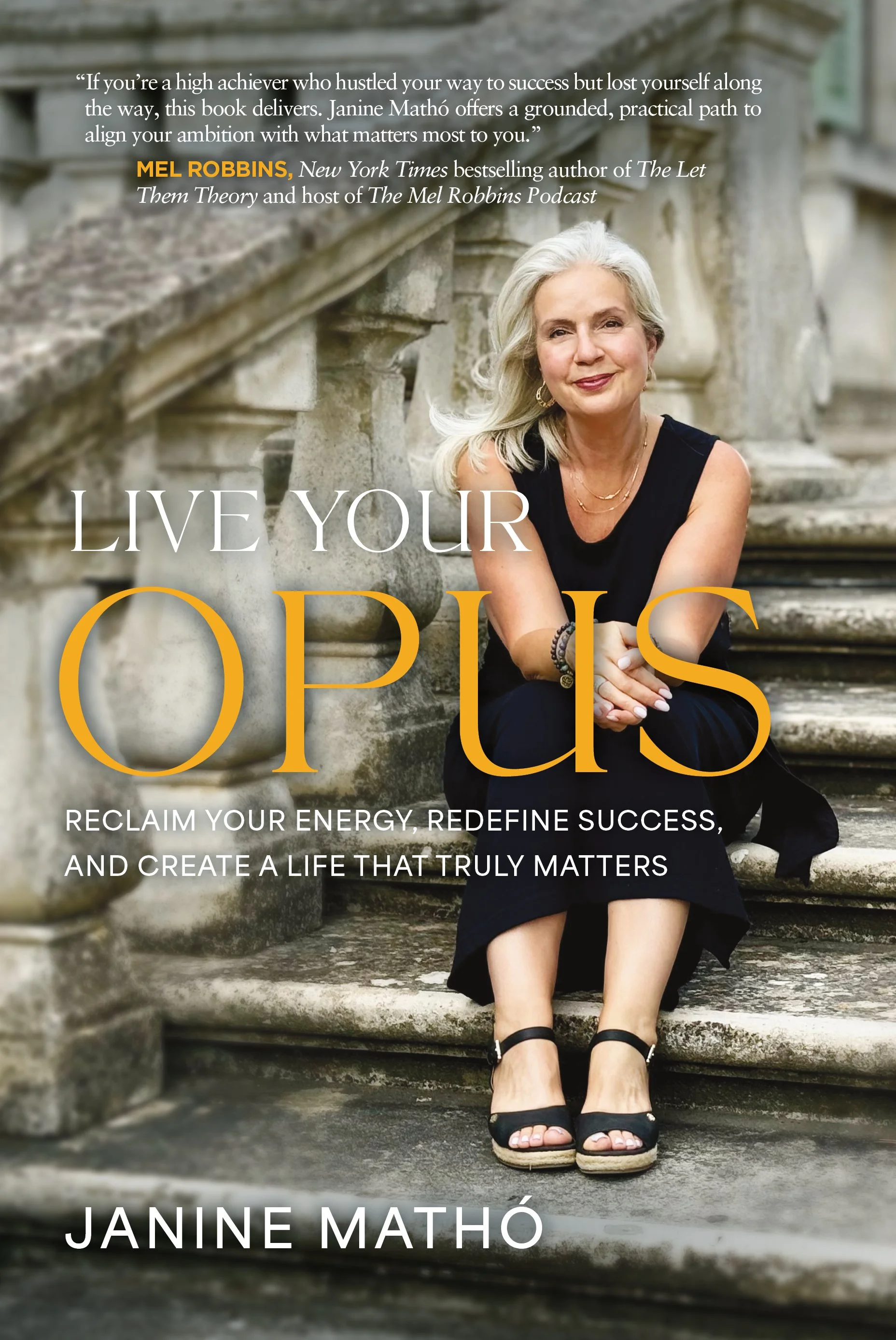 Book cover for 'Live Your Opus' featuring a smiling woman with gray hair sitting on stone steps, wearing a black dress and sandals, with a quote and author name Janine Mathó.