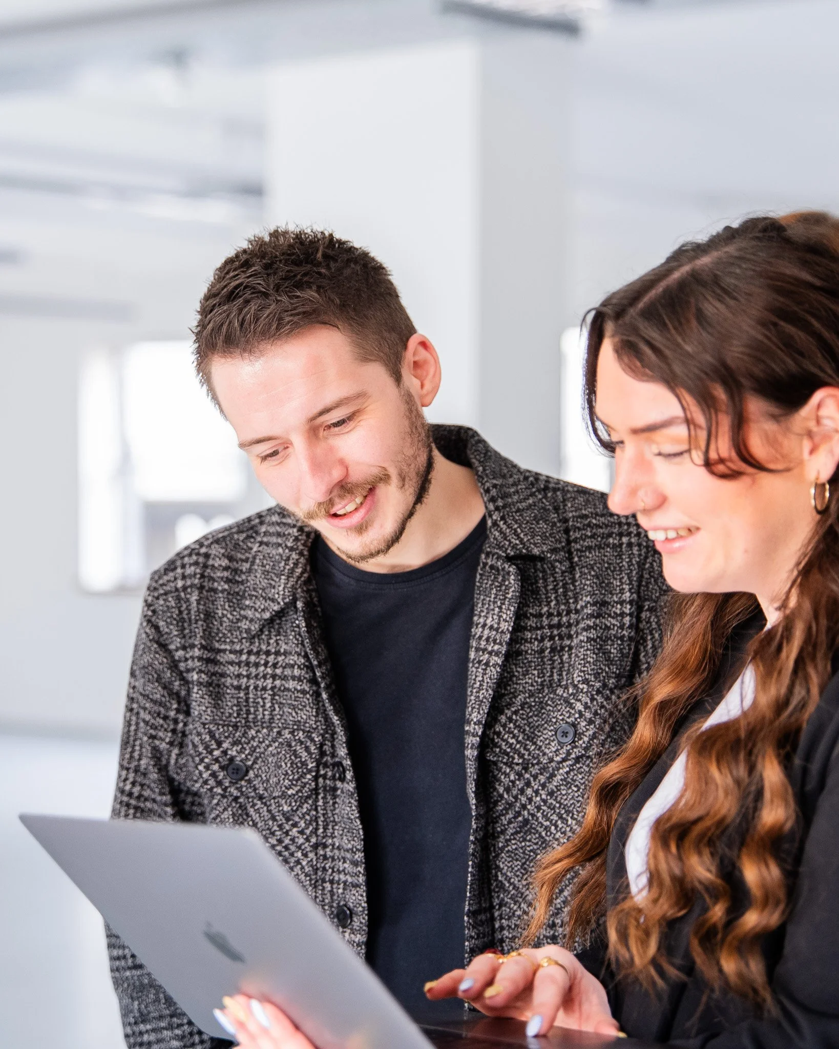 Lily Deal and a client looking at a tablet together in a bright office space