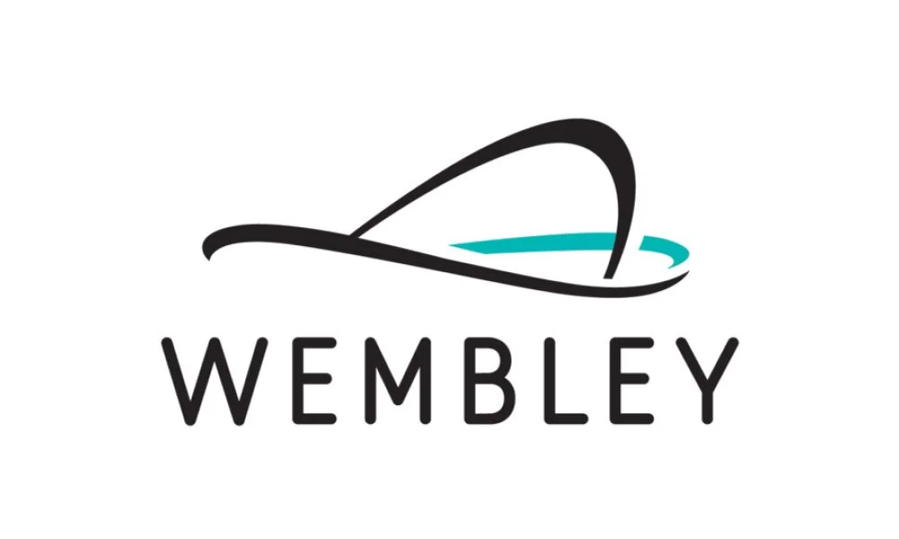Wembley logo featuring a stylized black arch and a blue curved line above the word 'WEMBLEY' in black text.