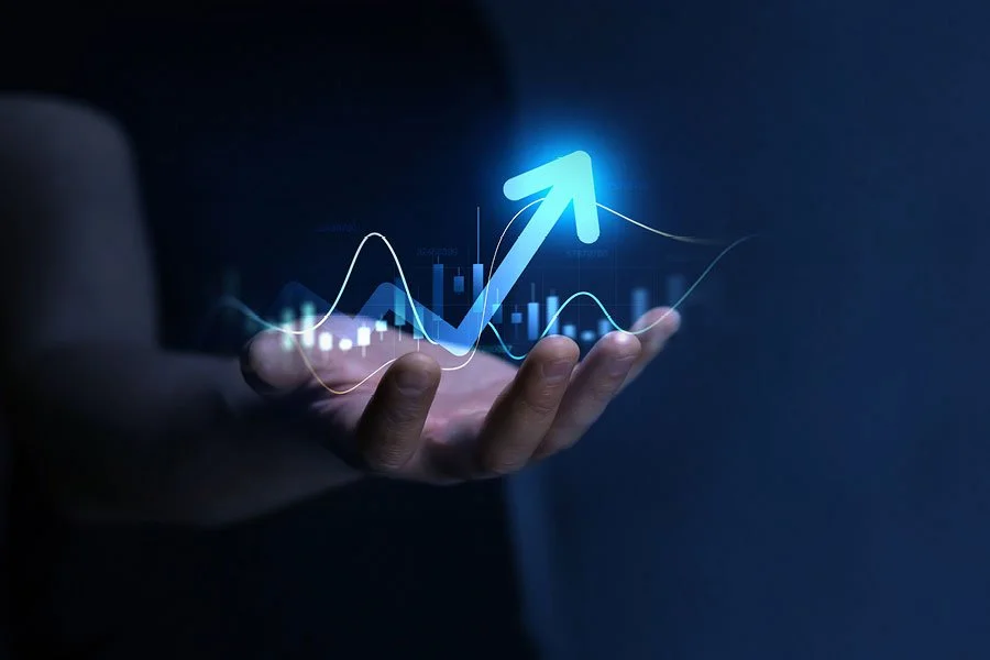 A hand holding a digital graph with a rising arrow, representing financial or data growth.