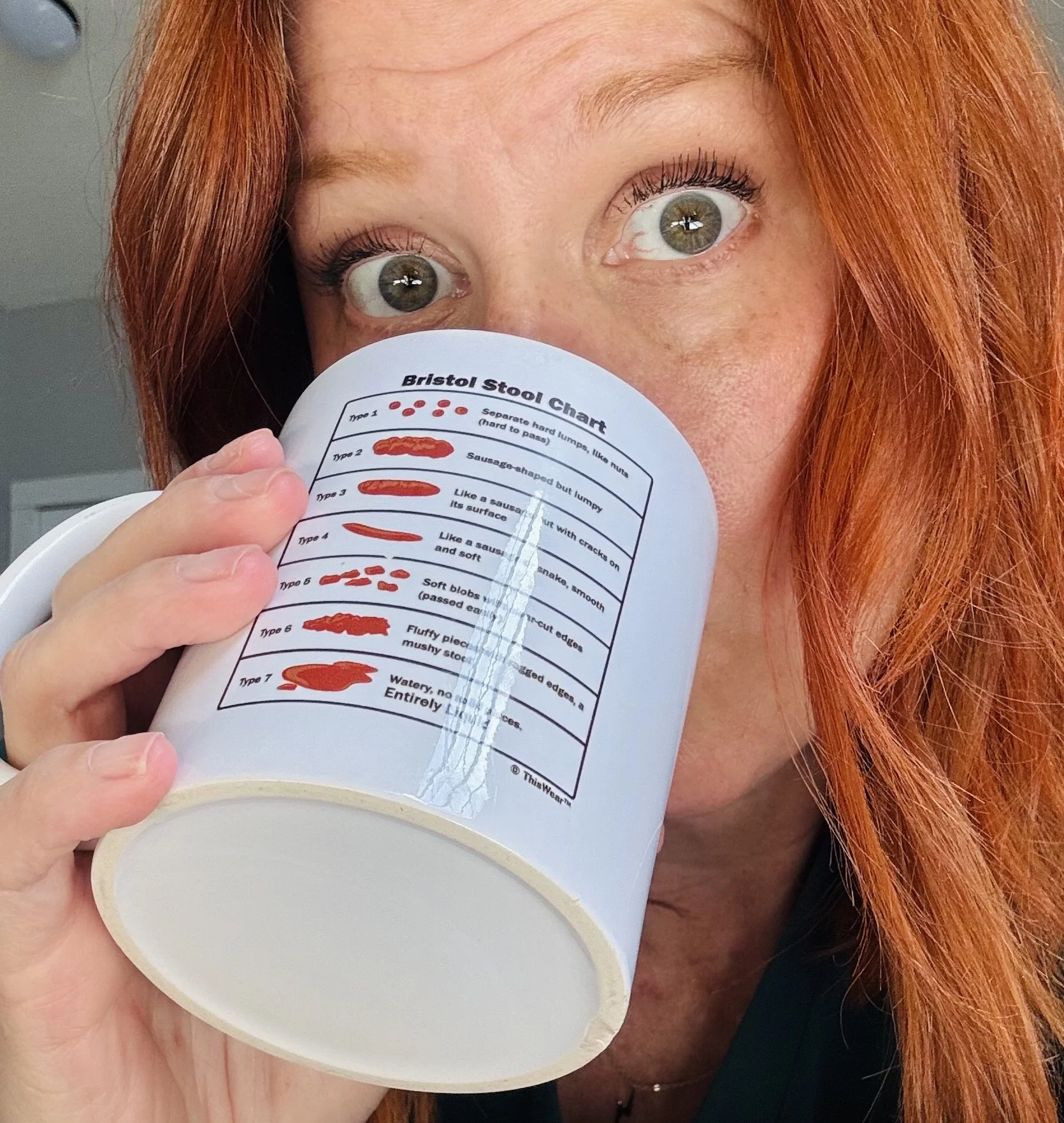 Dr. Liz Klekman drinking from her favorite coffee mug which has  a chart titled 'Bristol Stool Chart,' showing different types of stool textures and shapes.