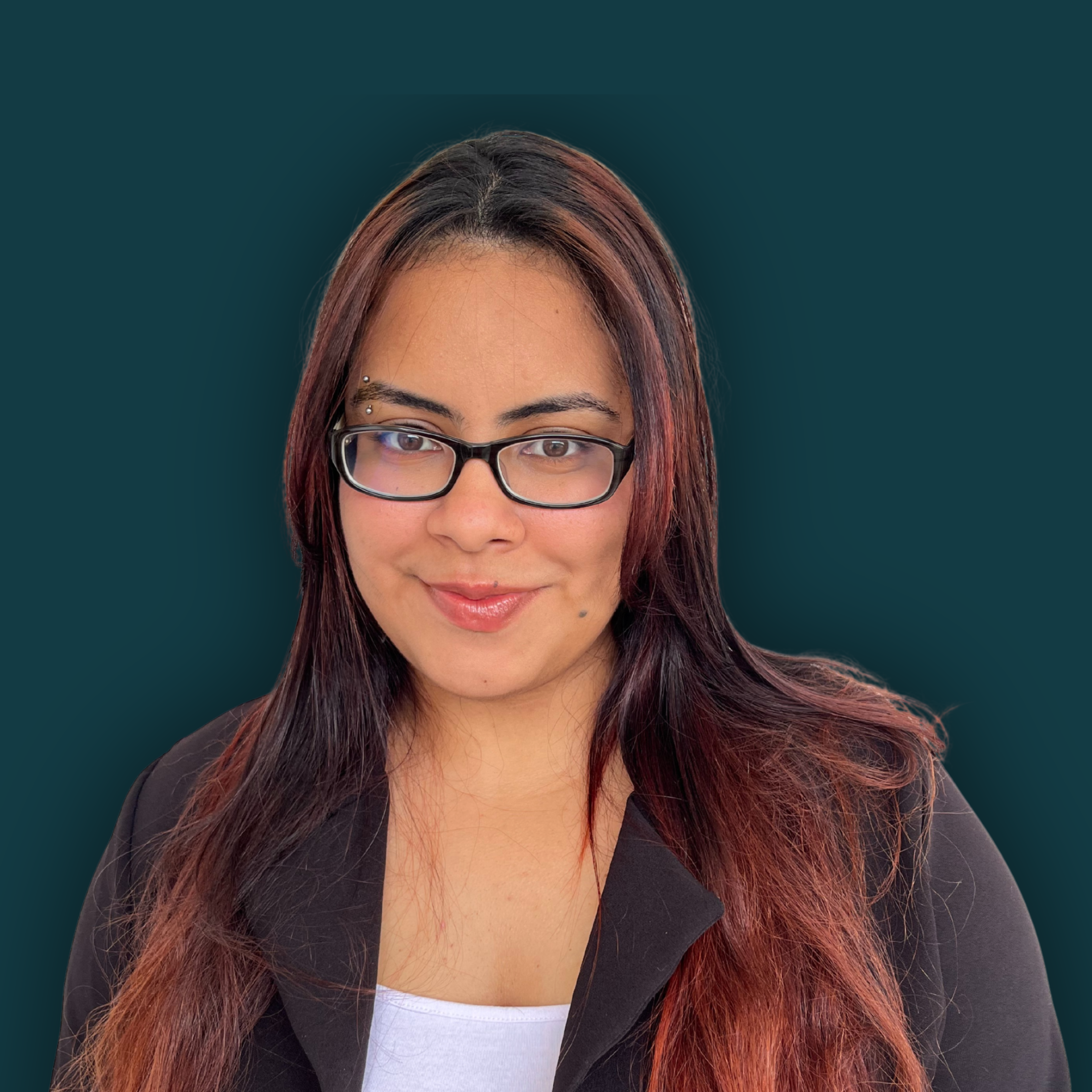 Head and shoulders portrait of a woman with light skin, glasses, dark red hair, smiling against a plain green background.