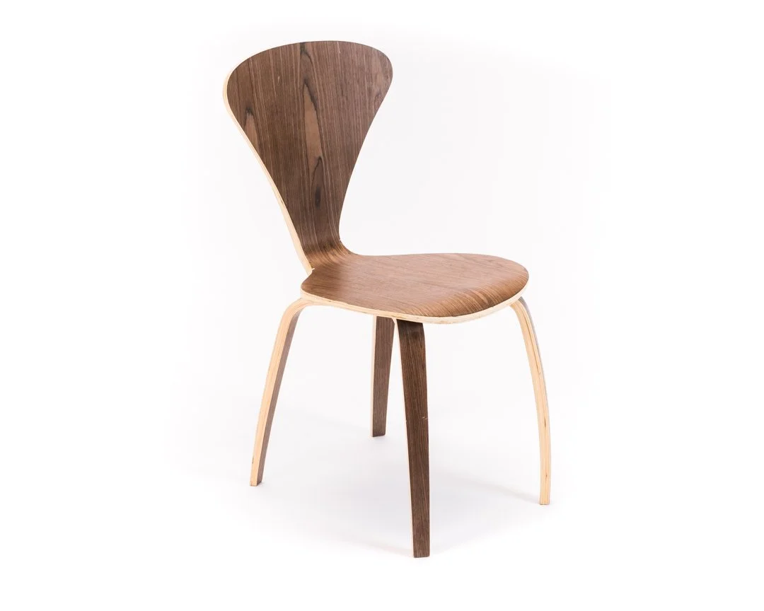 Wooden chair with a curved backrest and a round seat, standing on four angled legs, against a white background.