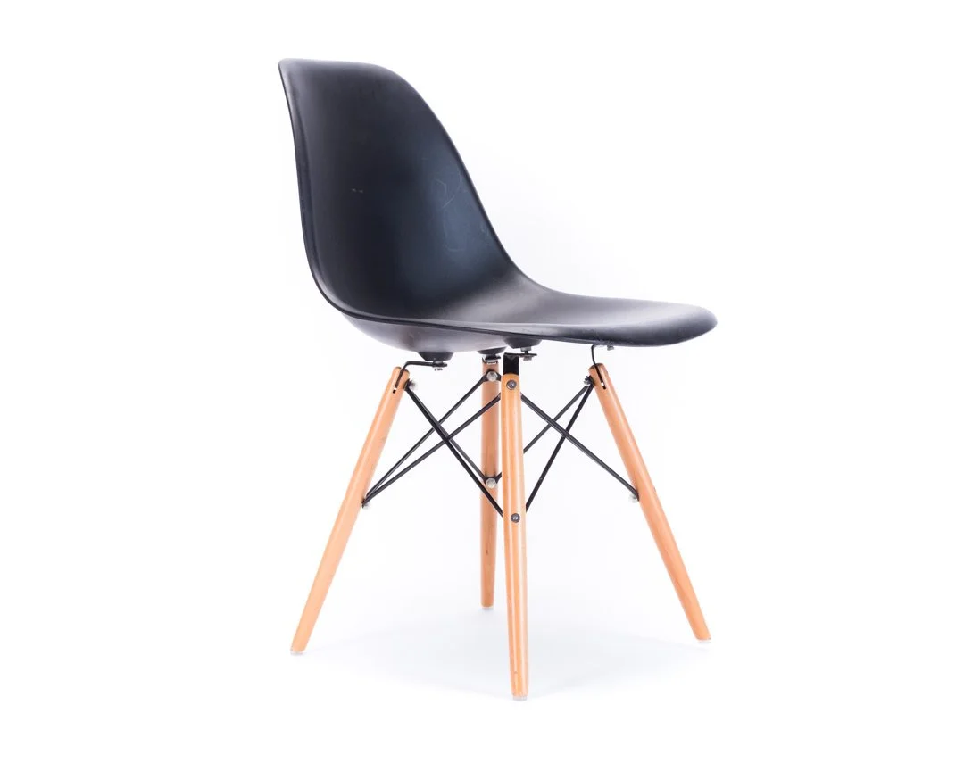 Black modern chair with wooden legs and black metal supports, facing slightly to the left, on a white background.