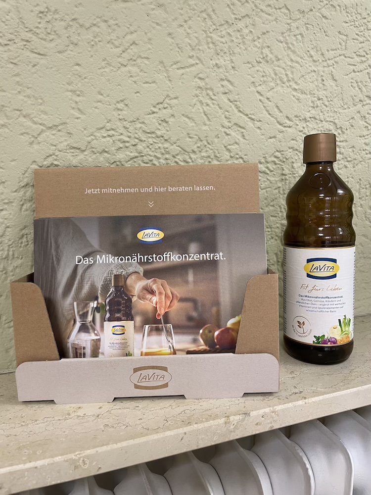 Eine Flasche Lavita und eine Broschüre stehen auf einer Ablage