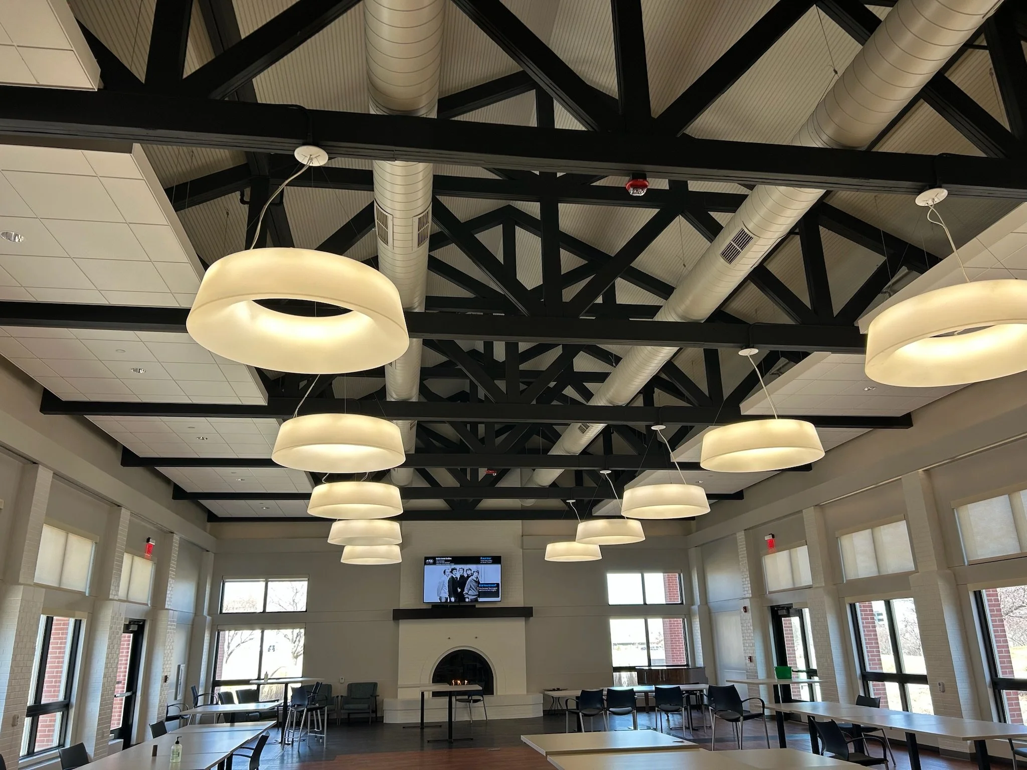 Open-ceiling commercial space with painted black beams and exposed ductwork