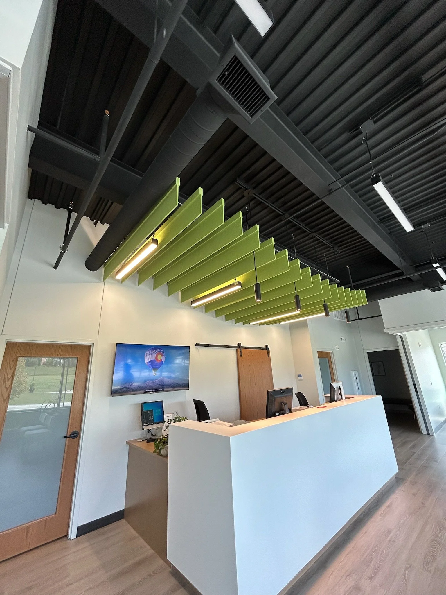 ainted office reception area with white front desk and green accent panels