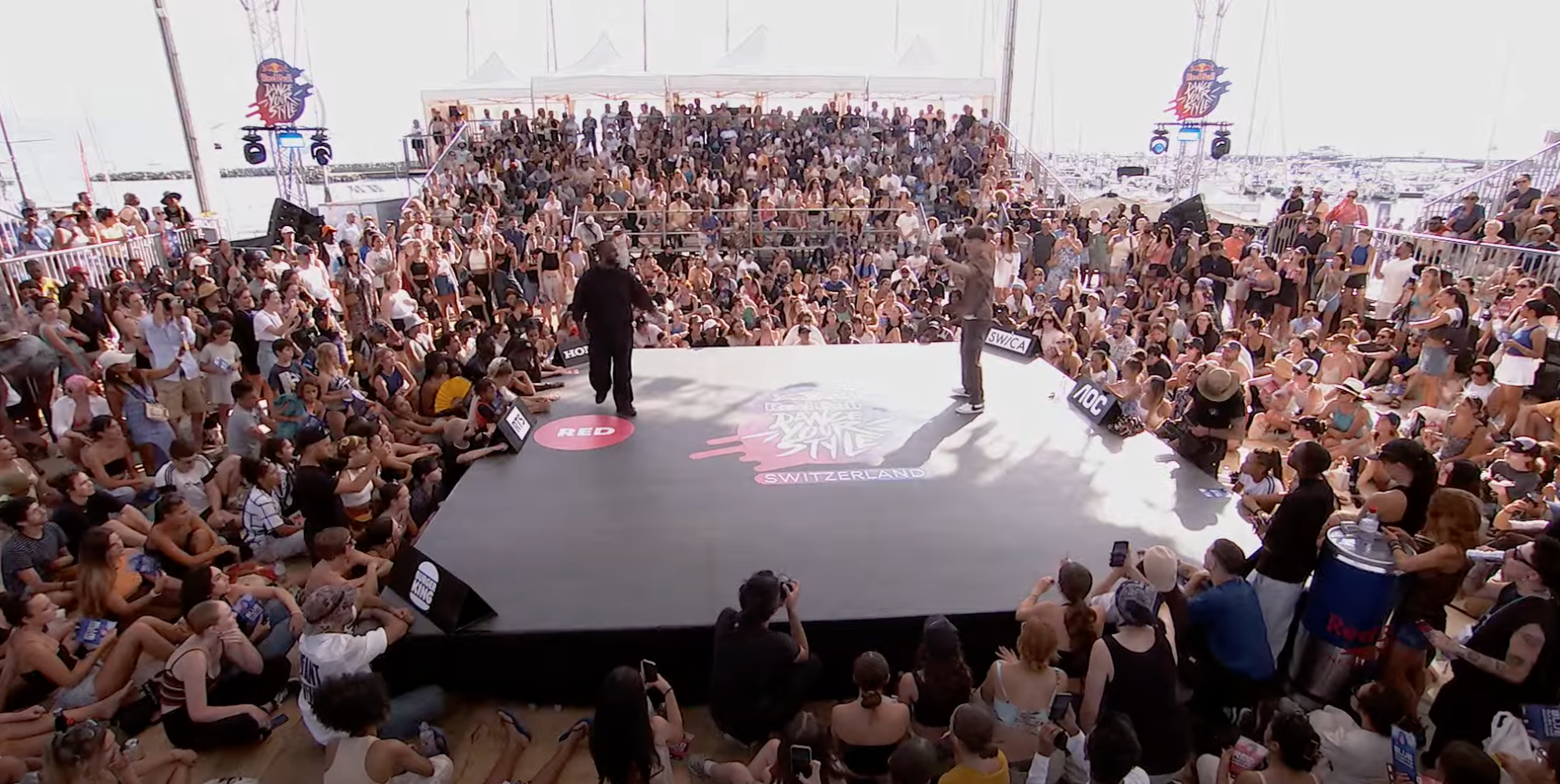 Großes Publikum bei einem internationalen Tanw-Wettbewerb im Freien, auf einer erhöhten Bühne mit Blick auf eine Marina mit Booten, Schweiz, auf einer Yacht-Eventfläche.