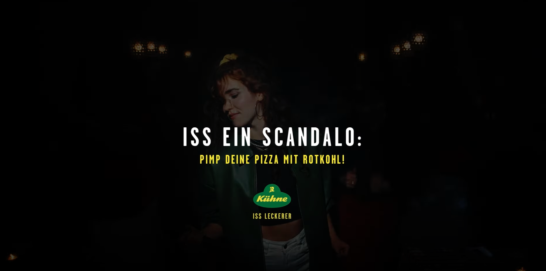Werbung für das Produkt Kühne, mit einem Text, der vor Skandal warnt und zum Essen aufruft, mit einem dunklen Hintergrund und einer Frau im Mittelpunkt.