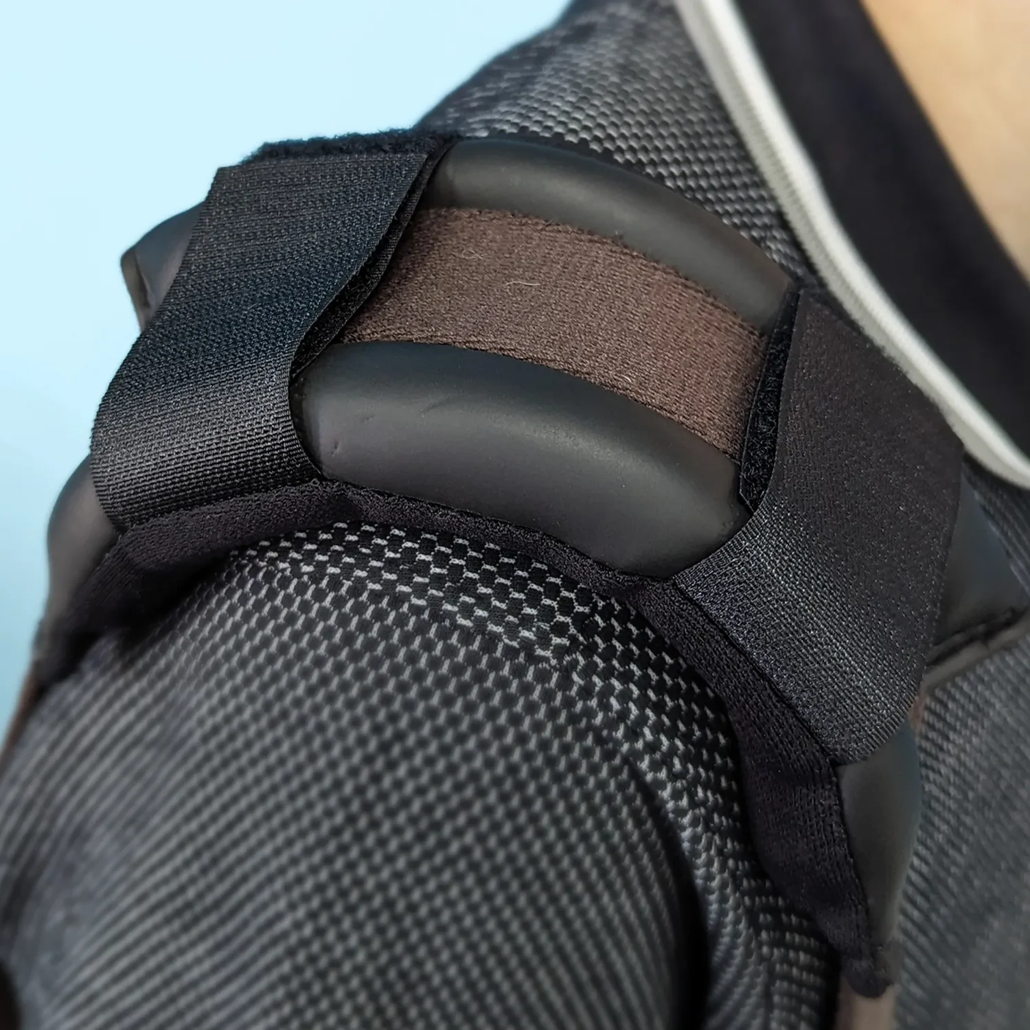 Close-up of a camera bag with padded dividers and straps, showing one compartment filled with a brown elastic strap.