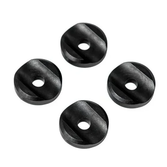 Four black rubber or plastic vibrating dampers with a hole in the center, arranged in a square formation.