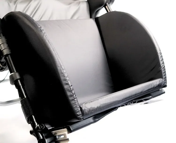 Close-up of a black wheelchair armrest and part of its frame.