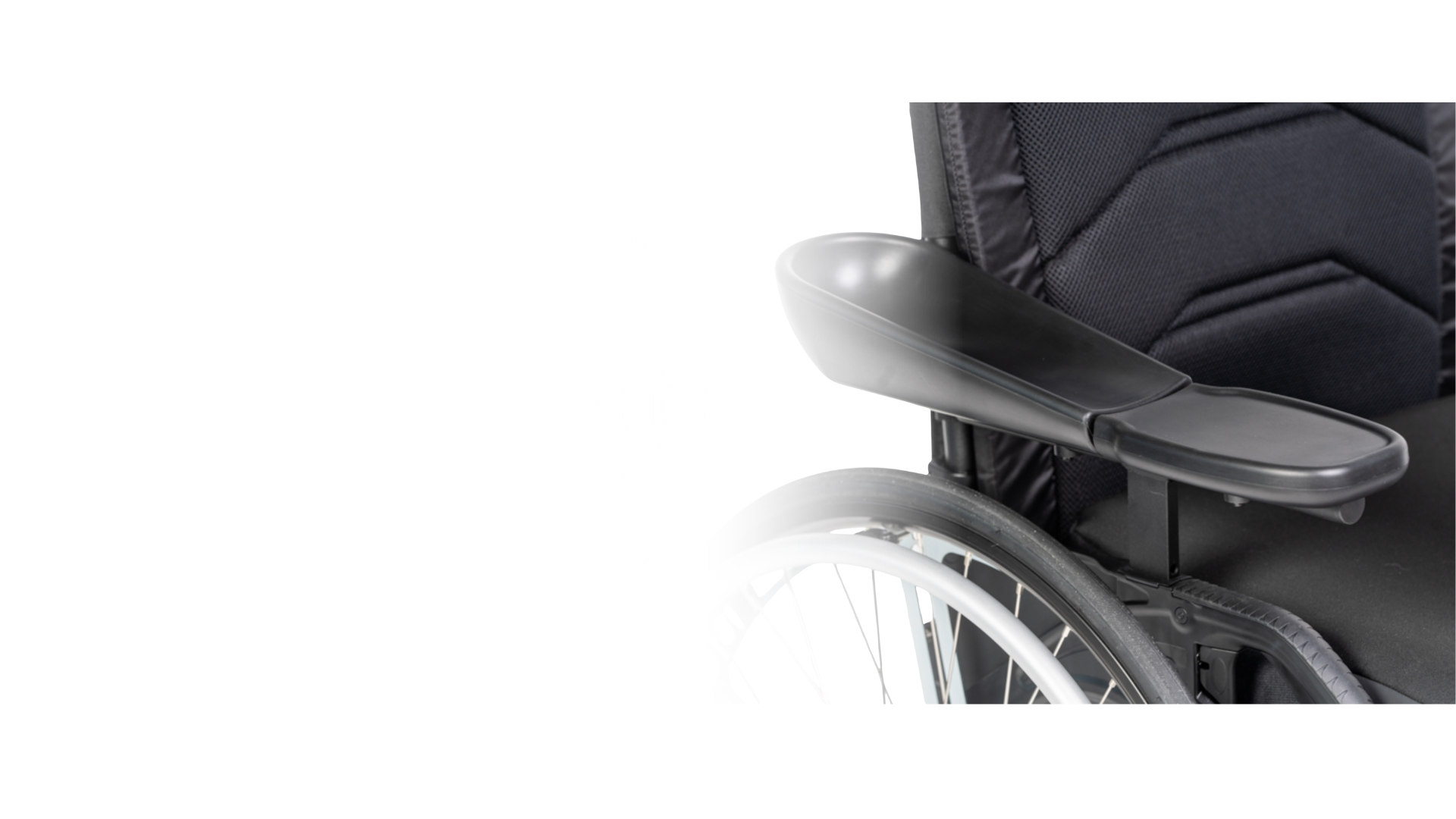 Close-up of a black wheelchair with a tray attached to its armrest, against a plain white background.
