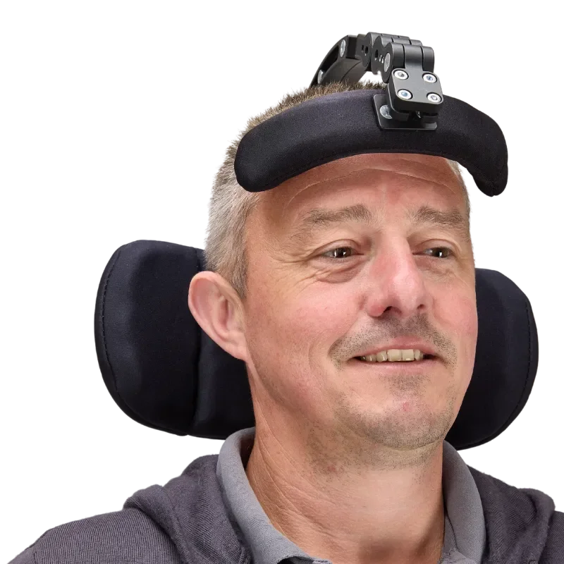 A man with a disability wearing a head-up display device on his forehead, sitting in a wheelchair.