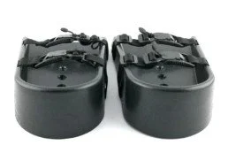 Pair of black foot pedals or shoe covers with straps and adjusting mechanisms.