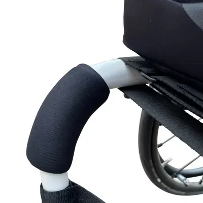 Close-up of a wheelchair's armrest and wheel.