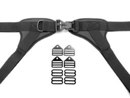 Close-up of adjustable black straps with a plastic buckle and amount of strap extenders or replacement parts.